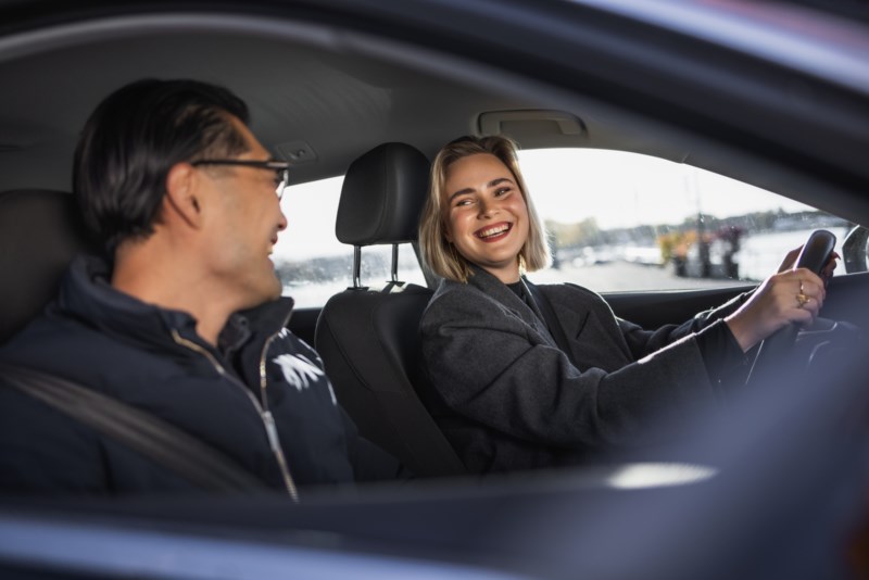 Mann og dame i bil som smiler til kvarandre